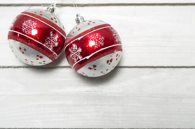 Christmas bauble decoration hanging on a light coloured wooden wall